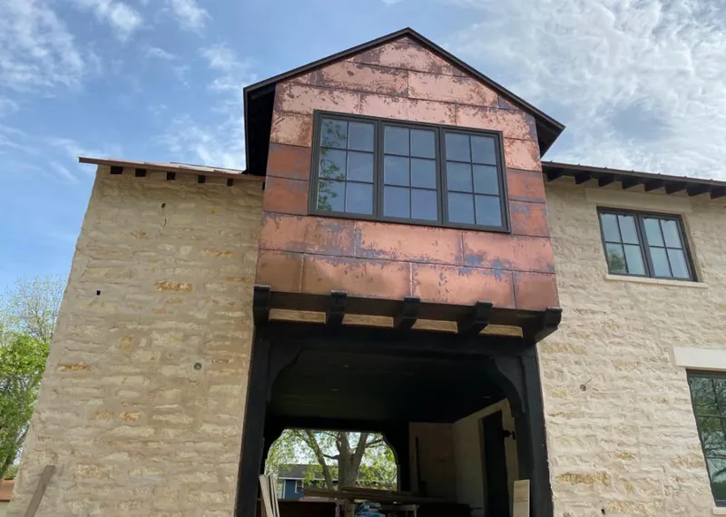 Copper metal panel facade on a stone building for Skylight Installation in Island Lake